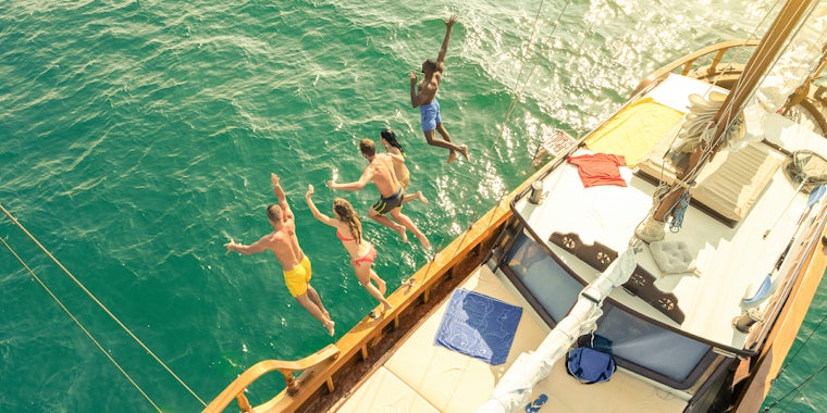 People jumping off of a boat into the water