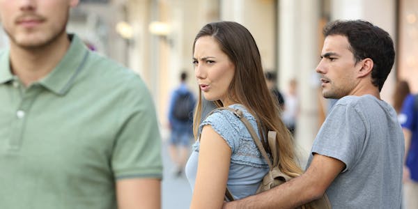 Distracted girlfriend looks at passing man