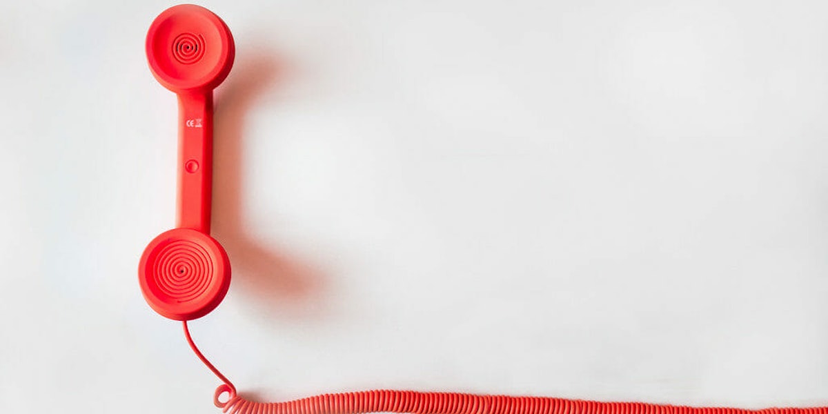 Red phone with cord on white background