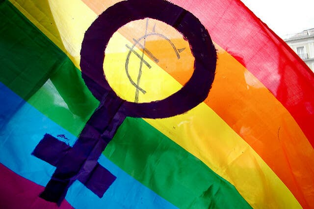 A rainbow flag sports the female symbol, representing women.