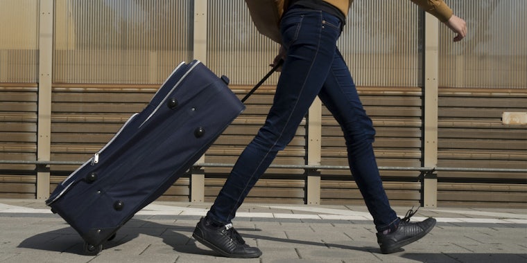 couchsurfing : Woman walking on train platform with luggage