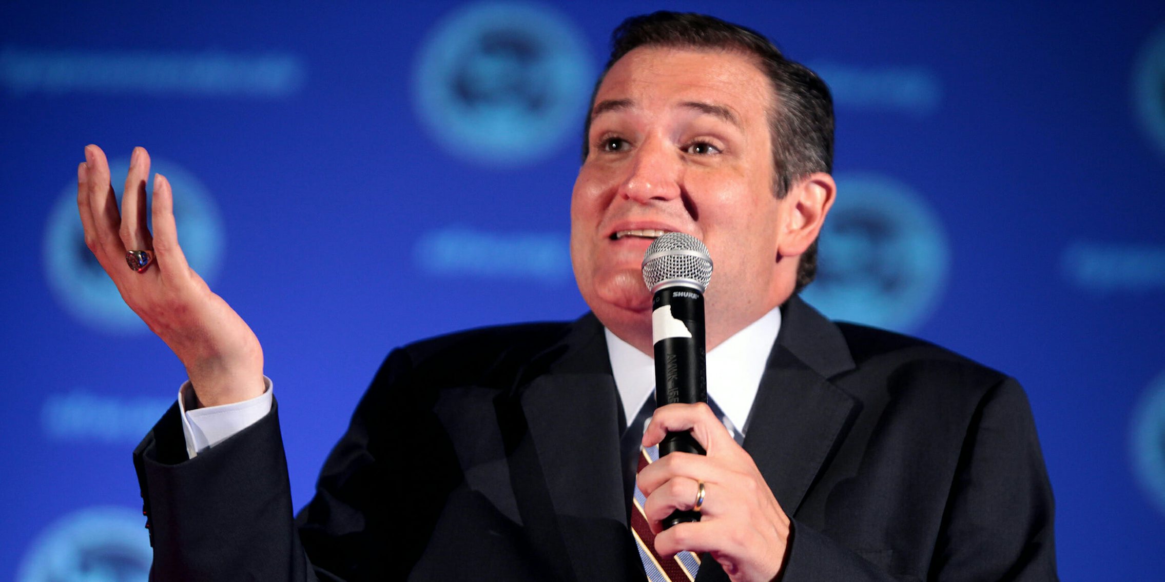 Ted Cruz shrugging his shoulders with one hand in the air