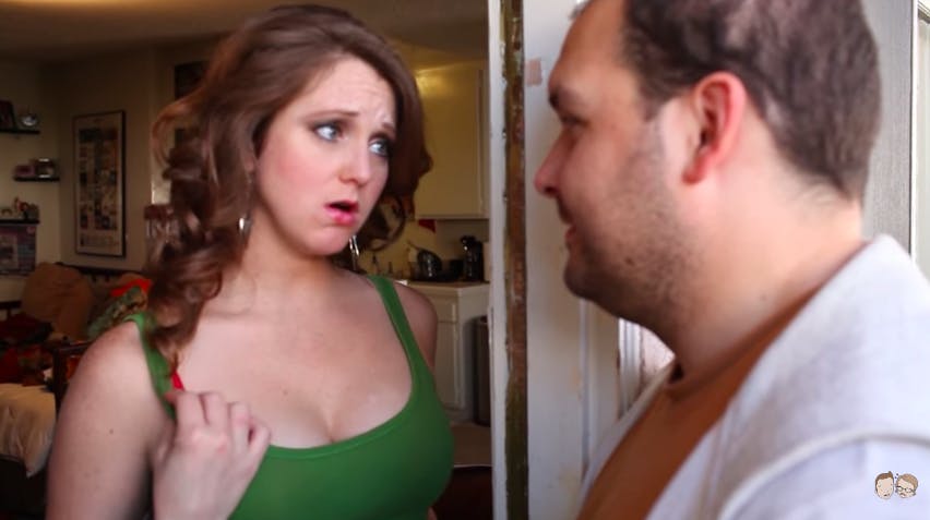 A woman answering a door and fondling her bra strap for Naughty America