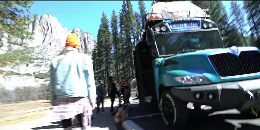 A screenshot from a Logan Paul vlog shows a tent strapped to his converted school bus in Yosemite National Park.