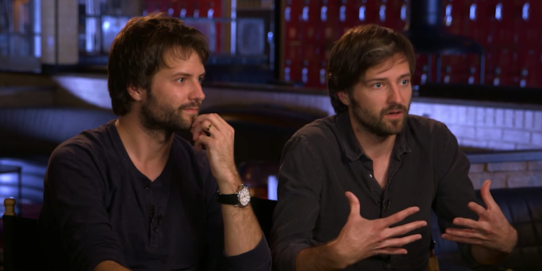 The Duffer brothers sit side by side in black shirts