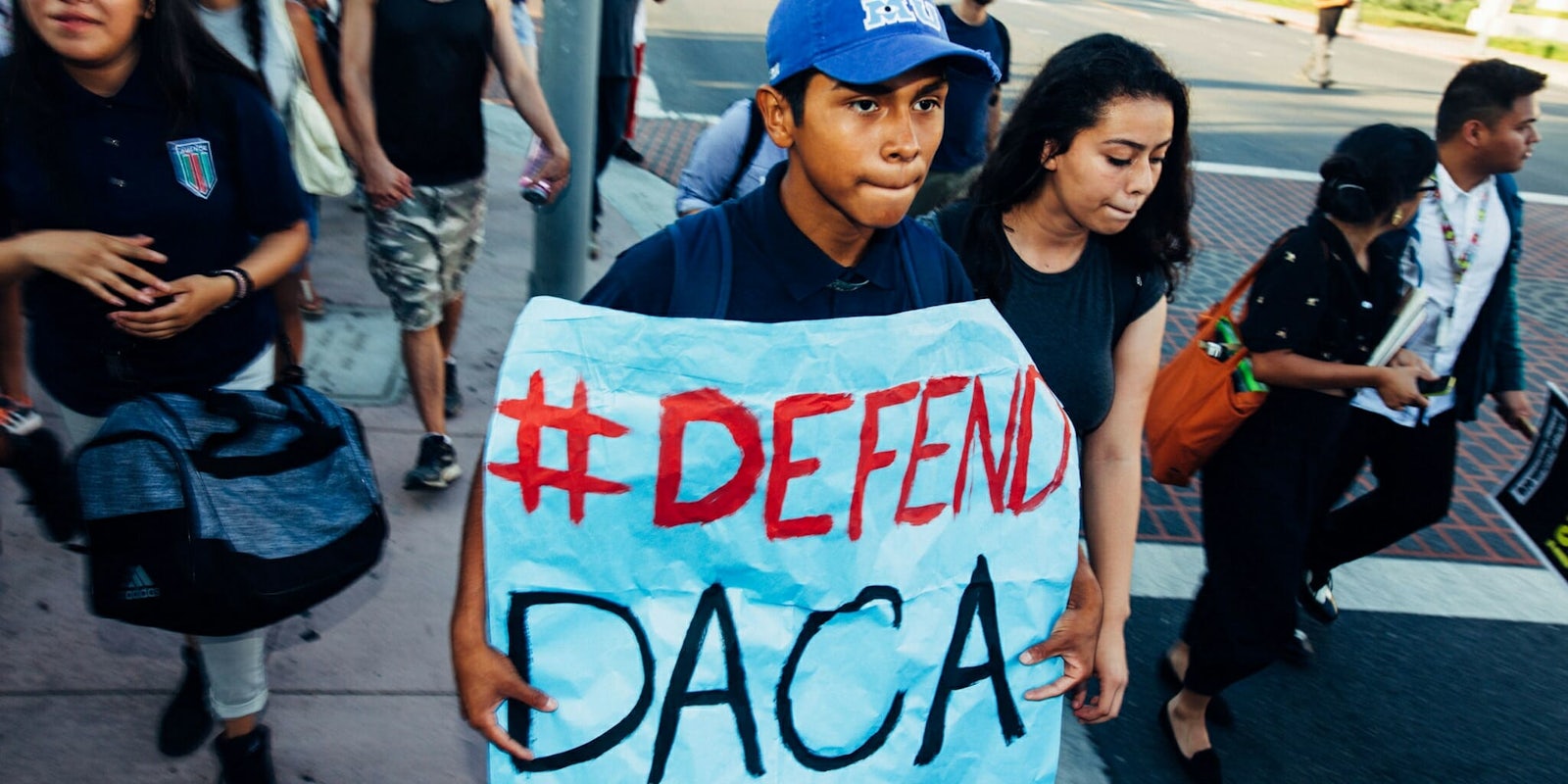 Protesters defending the Deferred Action for Childhood Arrivals (DACA) program with a poster stating 'Defend DACA.'