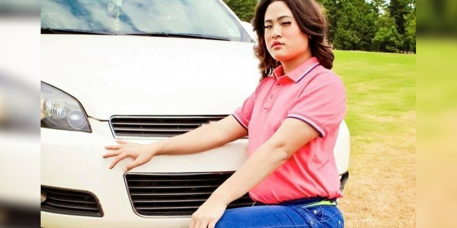 Kami Pham, a transgender teenager whose high school wouldn't let her present as a woman in its year book, kneeling in front of a car.
