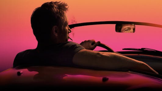 A man sits smoking in a convertible in an image from Californication