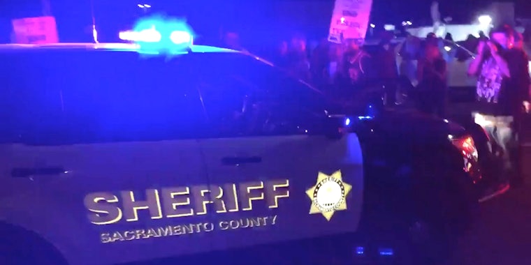 A car from the Sacramento County Sheriff's office moments before hitting a woman during a protest for Stephon Clark.