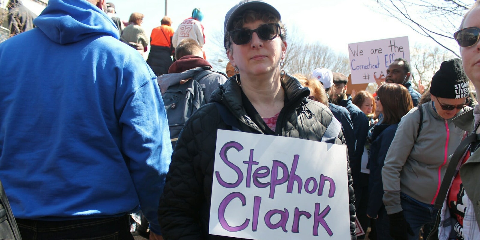 A protester at a March for Our Lives rally holding a sign with Stephon Clark's name on it.