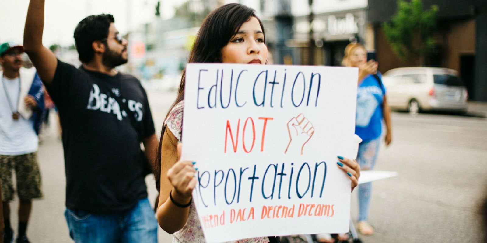 A woman holds a sign with the phrase 'Education not Deportation, Defend DACA Defend Dreams' at the Los Angeles March for Immigrant Rights.
