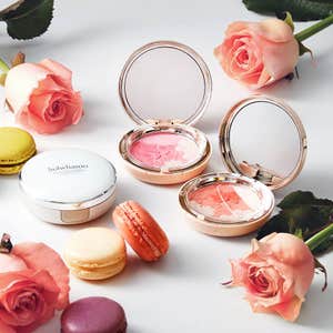 Beautiful Korean beauty brand Sulwhasoo compacts surrounded by roses and macarons