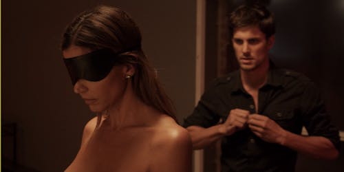 A man unbuttons his shirt as a naked woman stands blindfolded in this Amazon Prime porn scene
