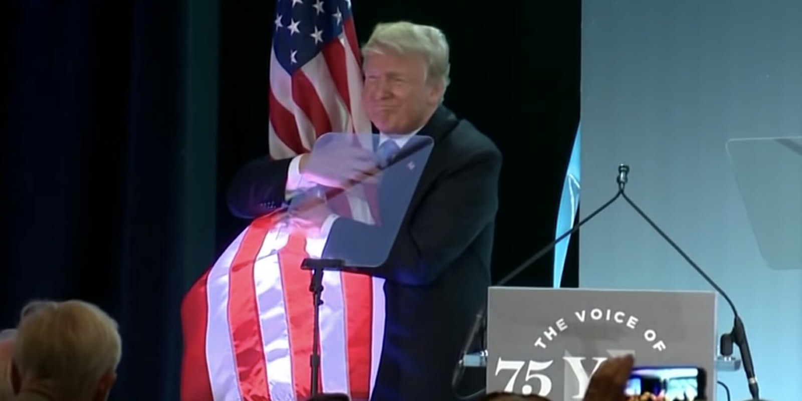 Trump hugs American flag