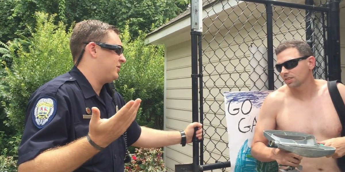 A police officer speaks to Adam Bloom at the pool entrance after he called the police on a Black neighbor.