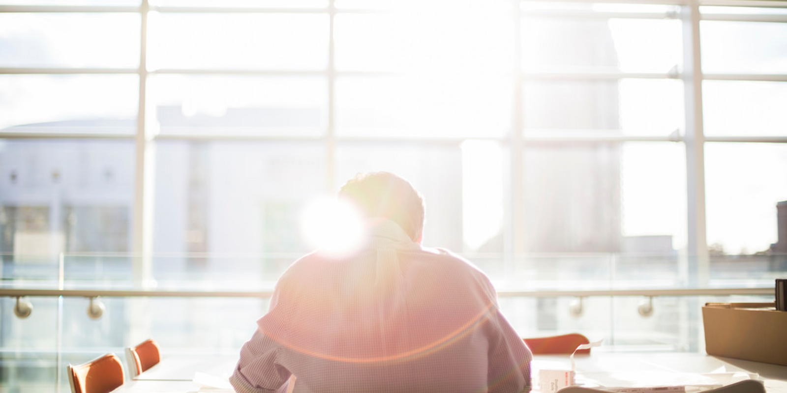 Man working at a table with lens flare