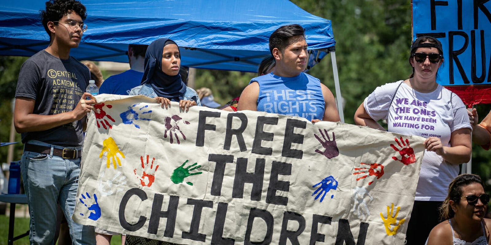 Protesters with a sign that says 'free the children.'