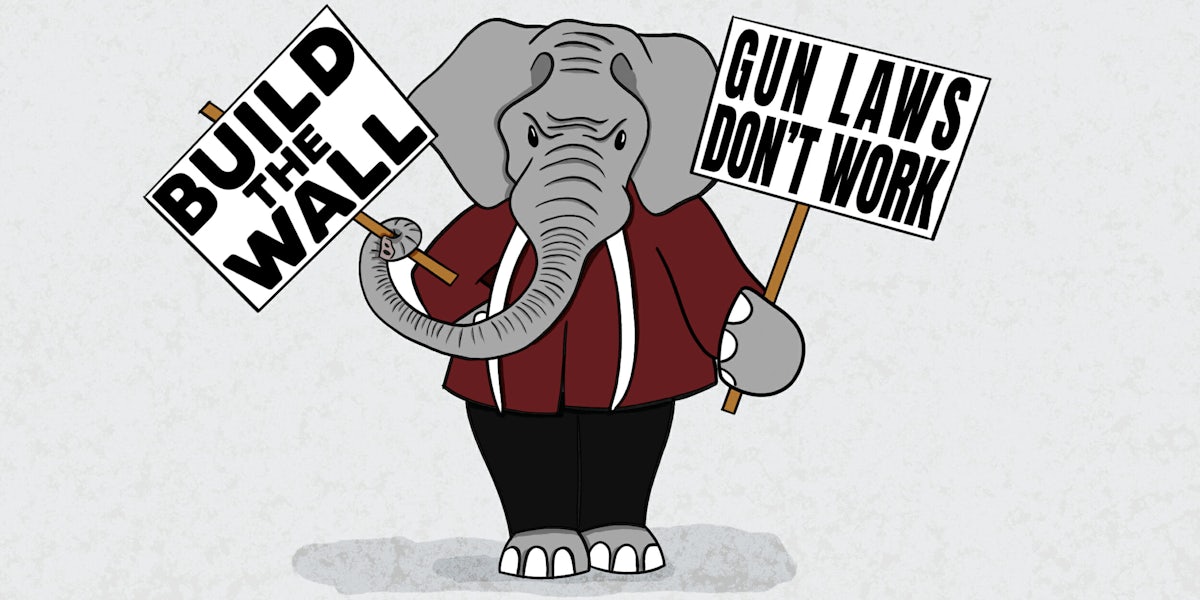 gop elephant holding protest signs that read 'build the wall' and 'gun laws don't work'