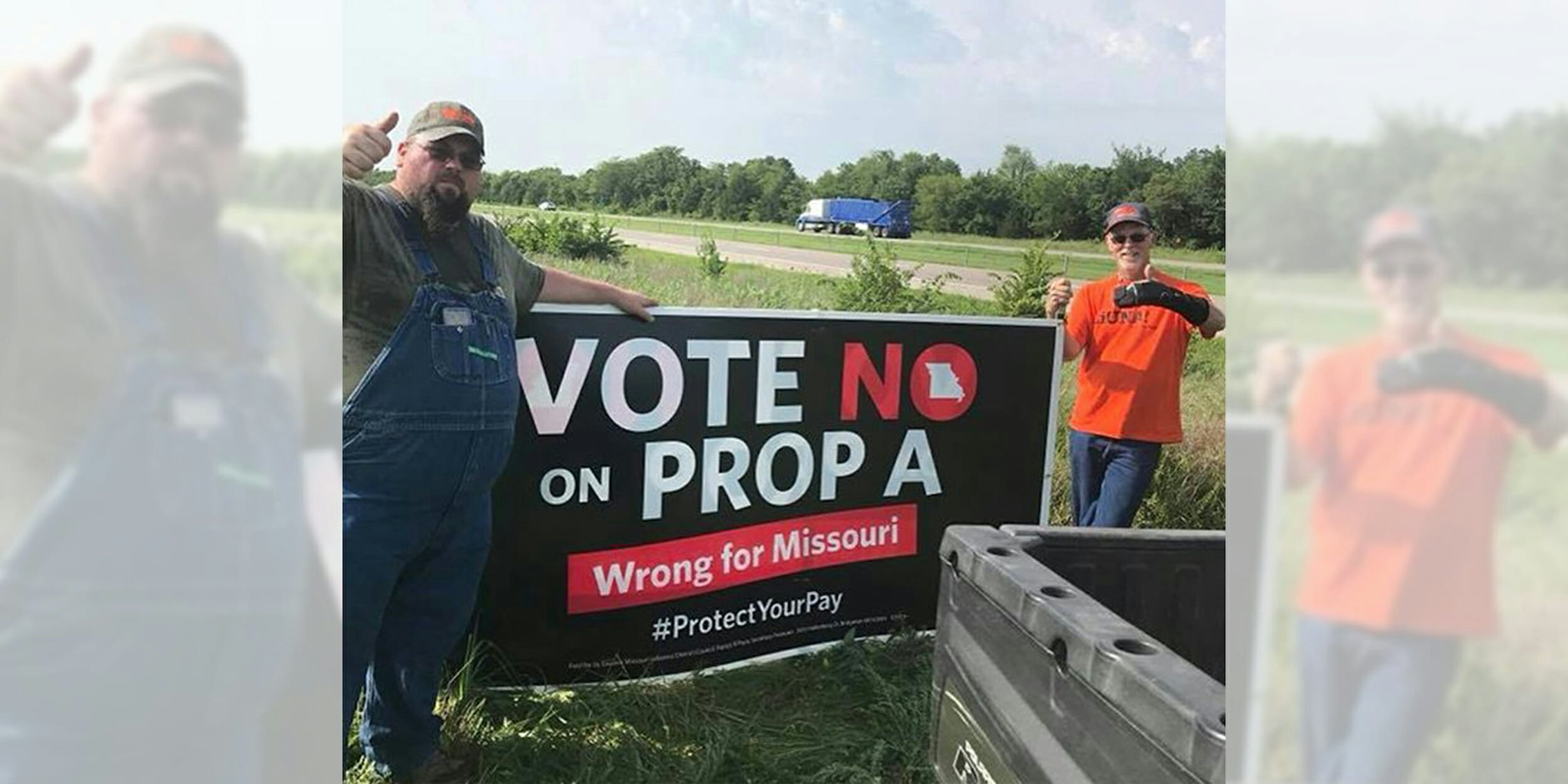 two men holding a 'vote no on prop a' sign