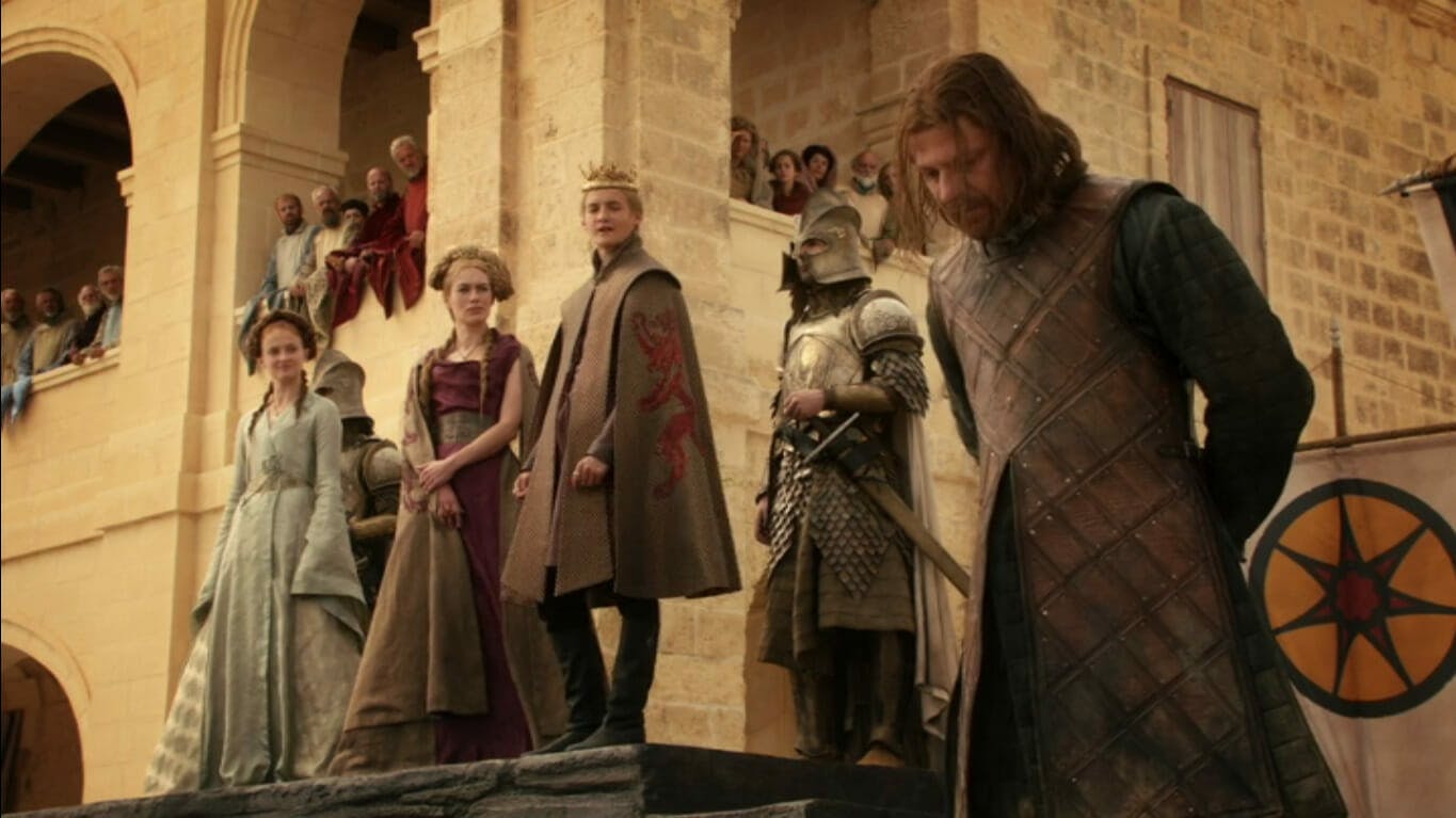 Image showing Eddard Stark with his hands tied behind his back, as Joffrey stands behind him