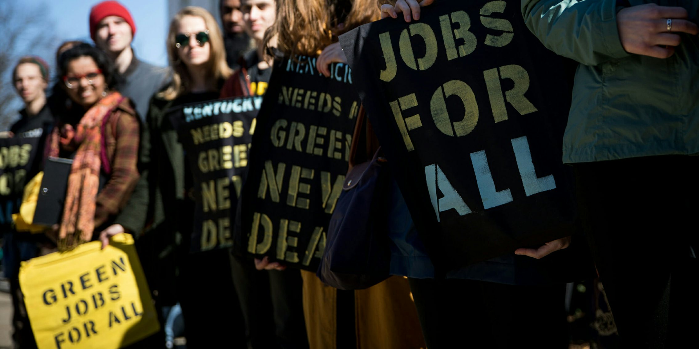 people holding green new deal signs