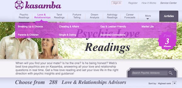 A couple gazes lovingly at each other as they walk together behind a banner for psychic love readings
