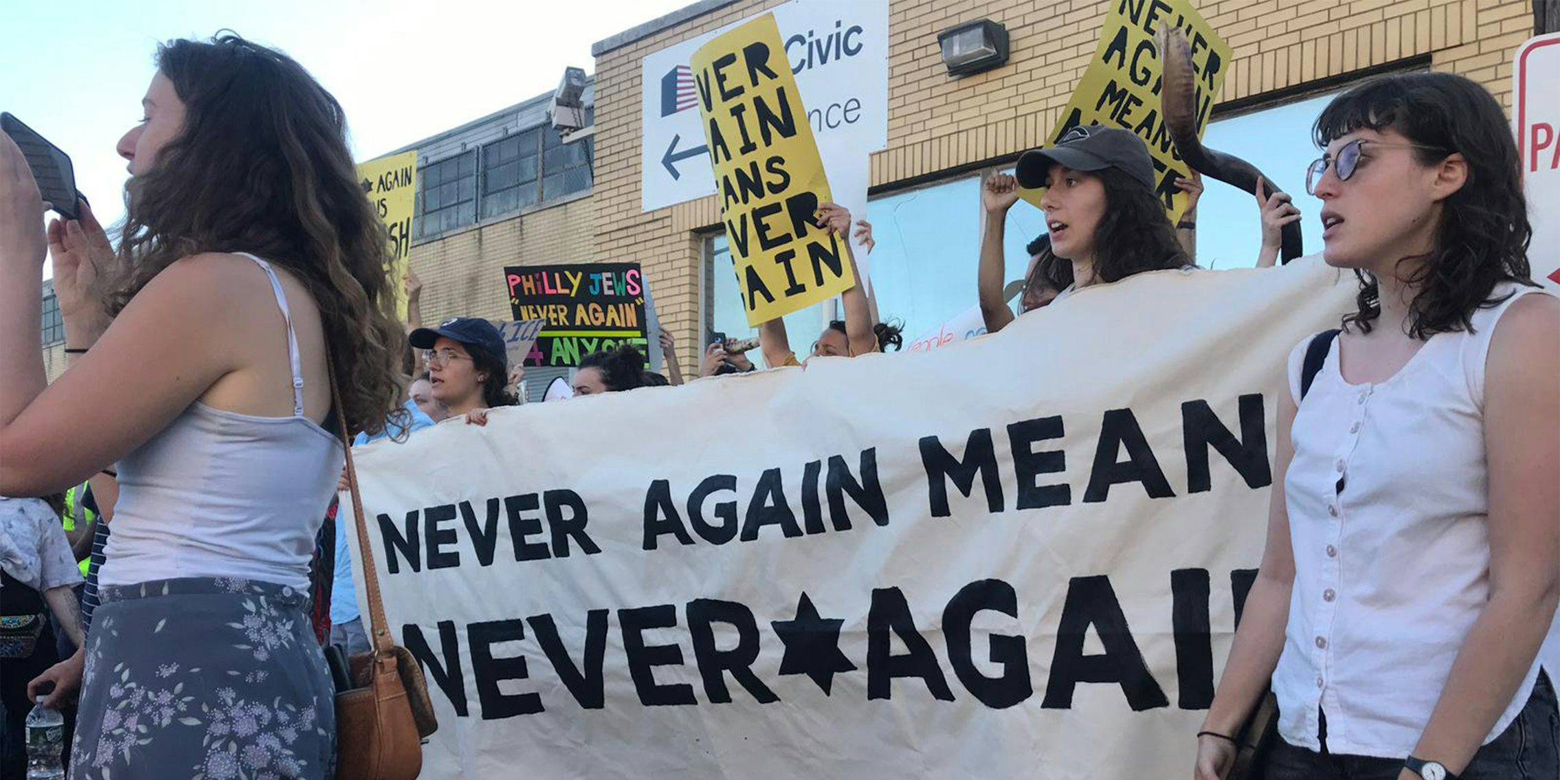 'never again means never again' banner held at ICE protest