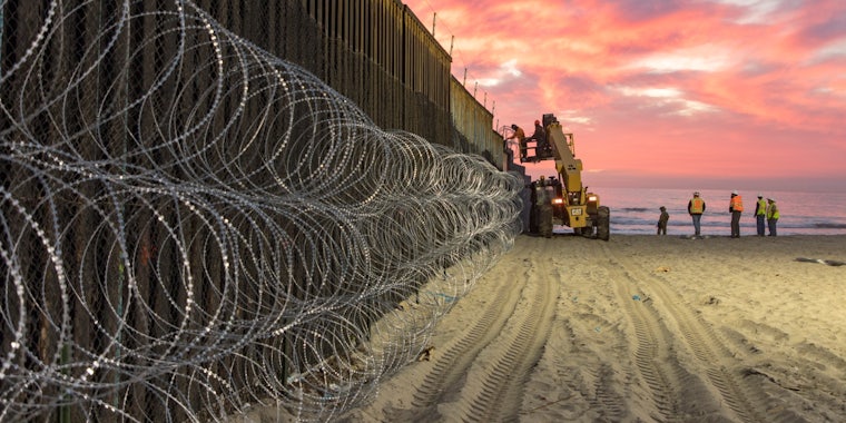 U.S. Border Patrol Agents in San Diego seen behind barbed wires at the border