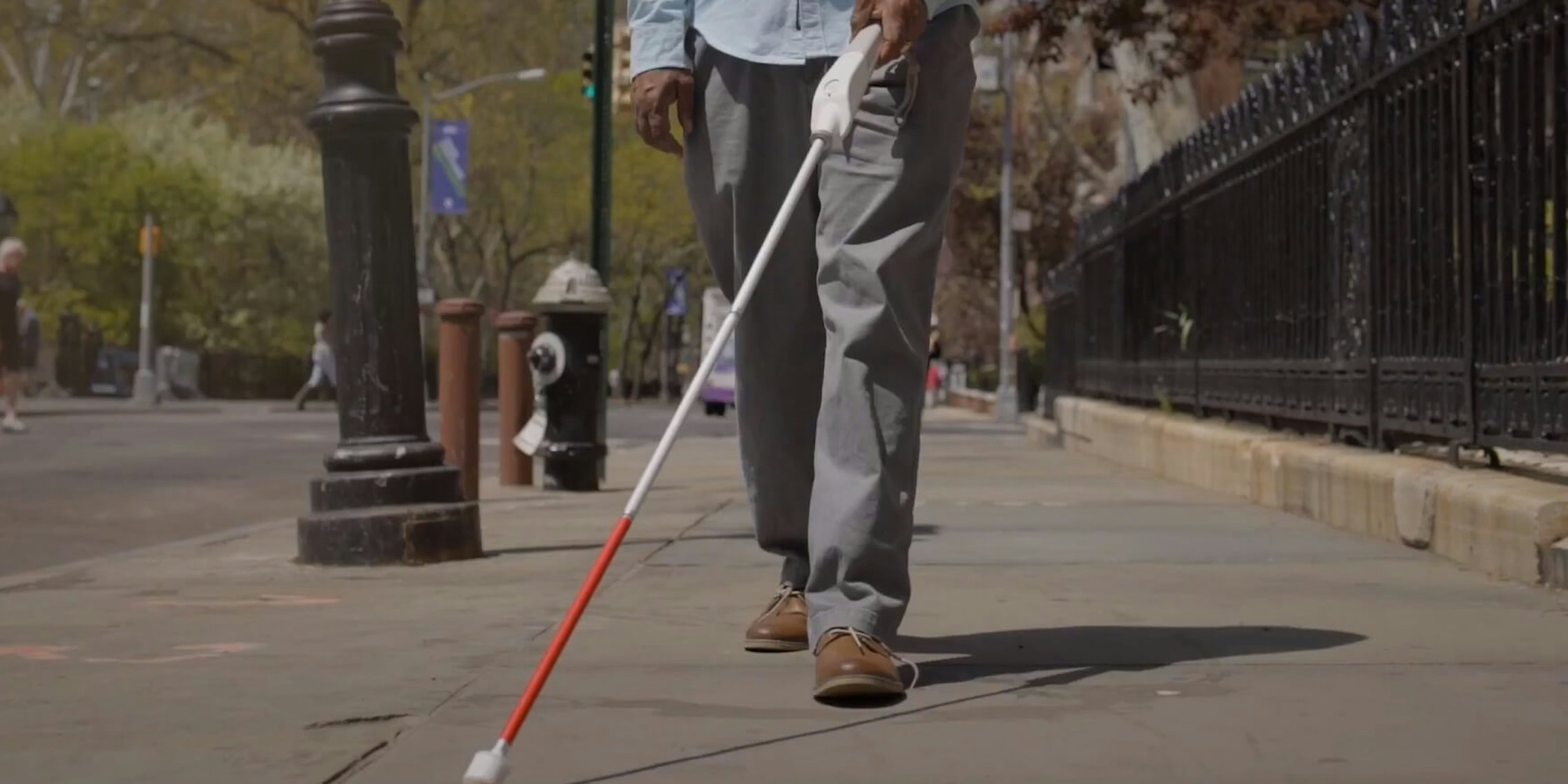 man using wewalk smart cane to navigate street