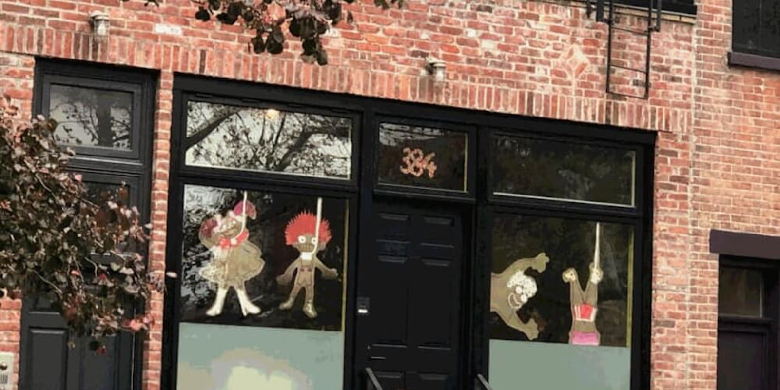 Window decorations show caricatures of children made out of brown paper seen in nooses