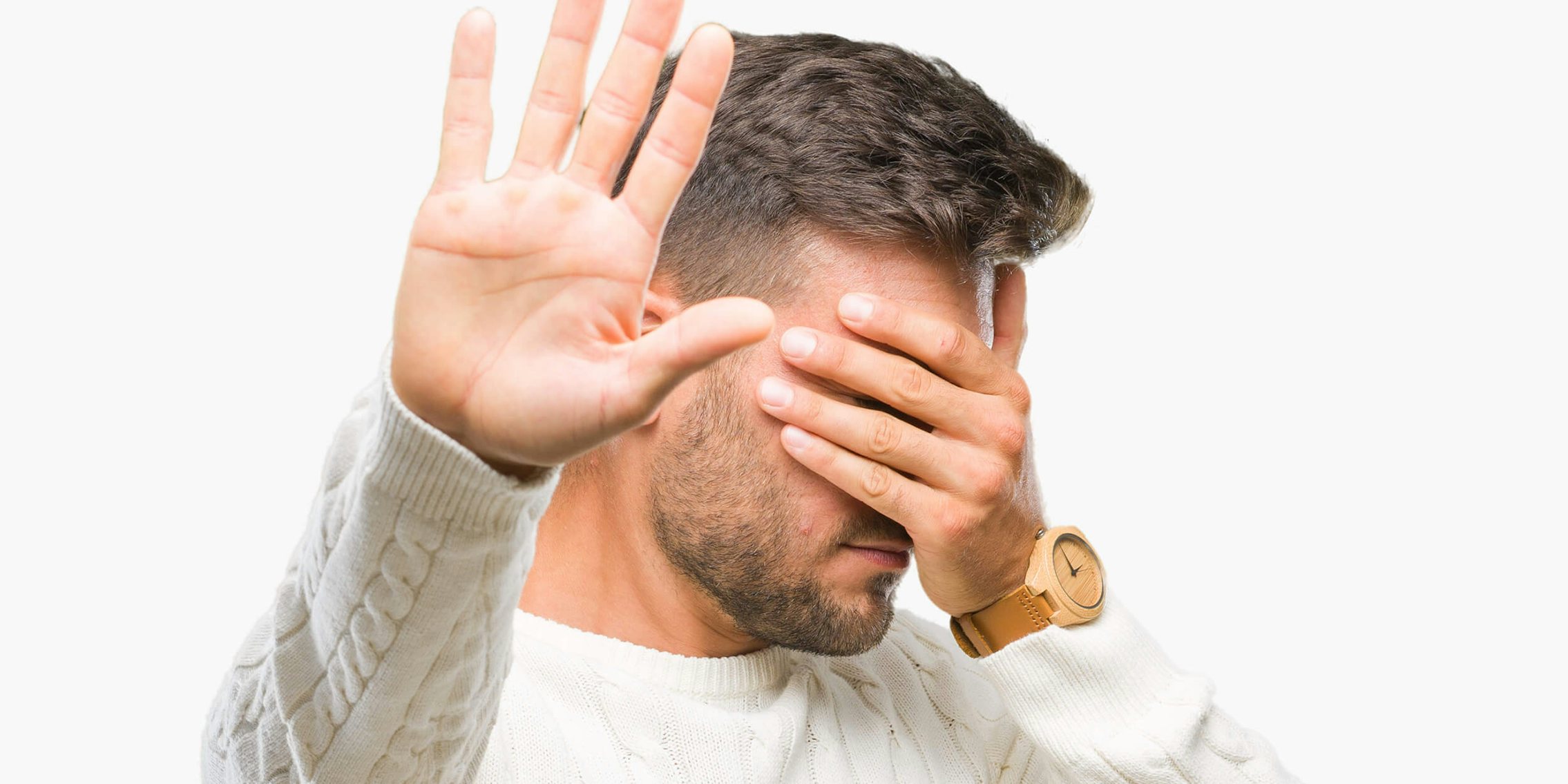 man covering eyes, placing hand up to stop