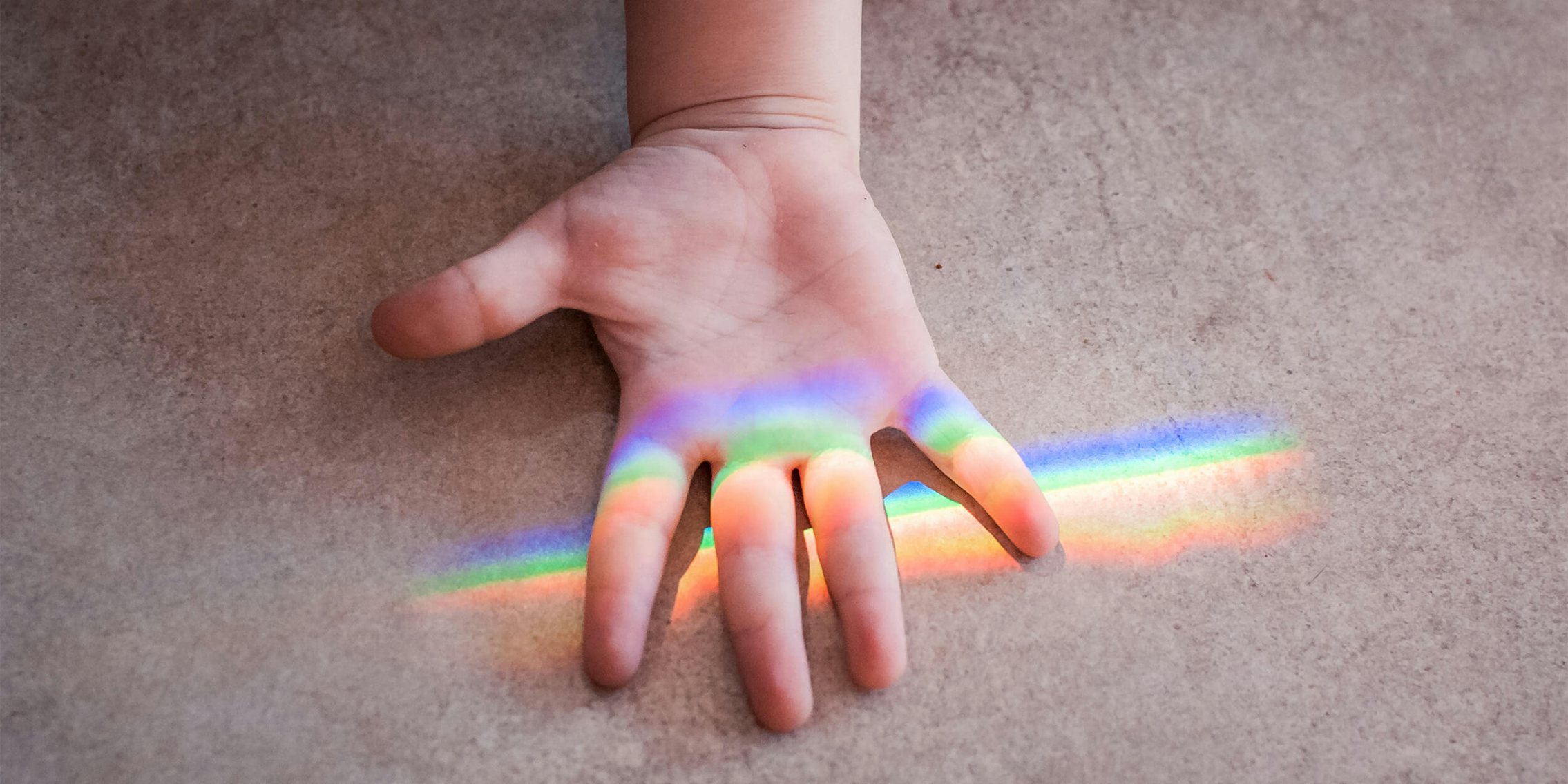child's hand under rainbow / protect james younger