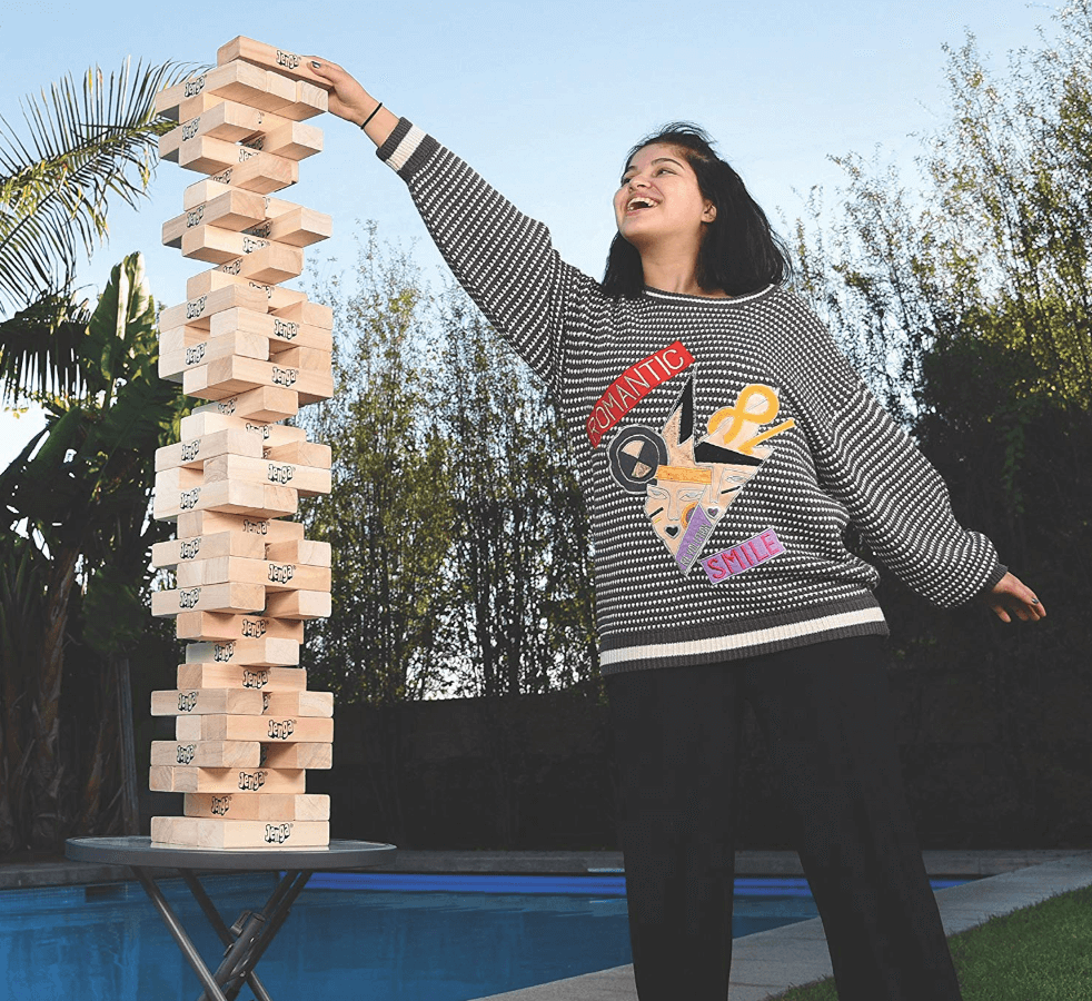 woman playing giant jenga outdoors