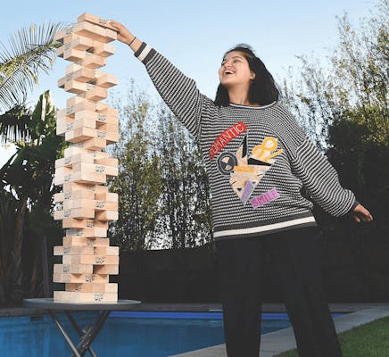 woman playing giant jenga outdoors