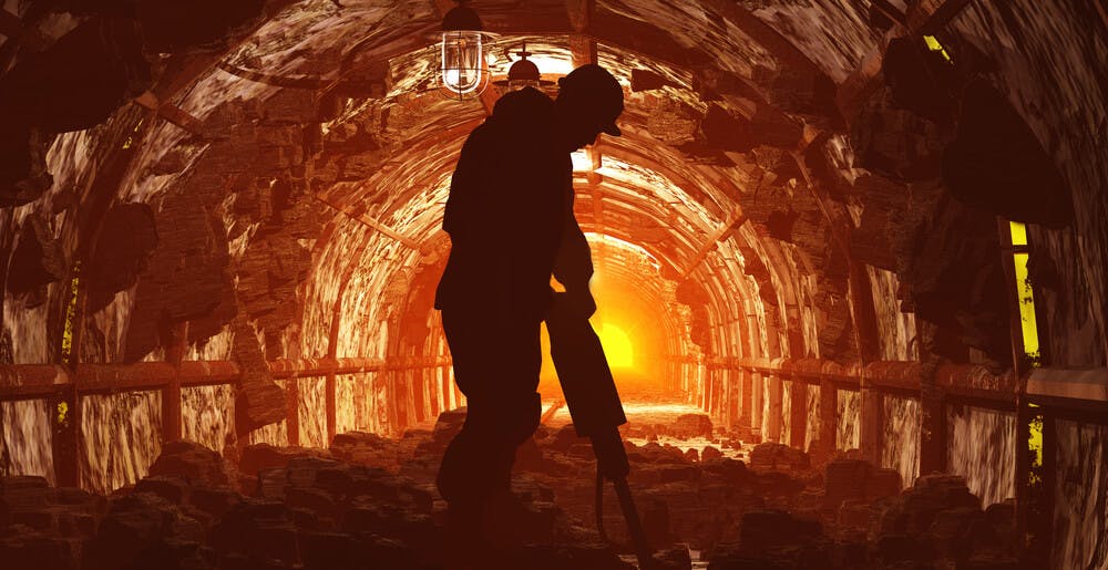 silhouette of miner in shaft