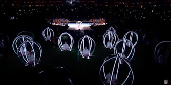 Children in a a sea of oval shaped carriages illuminated with white cage-like borders