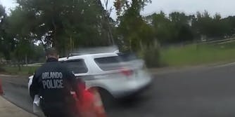 An Orlando officer is seen putting the wailing 6yo in the car