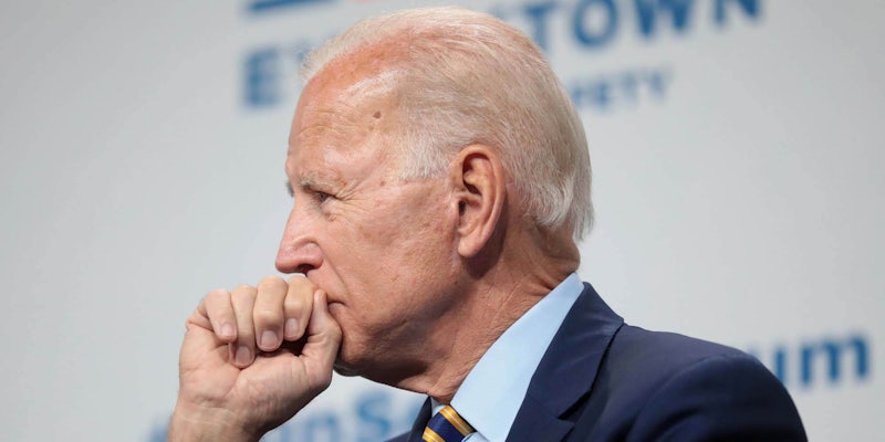 Joe Biden holding his fist up to his mouth