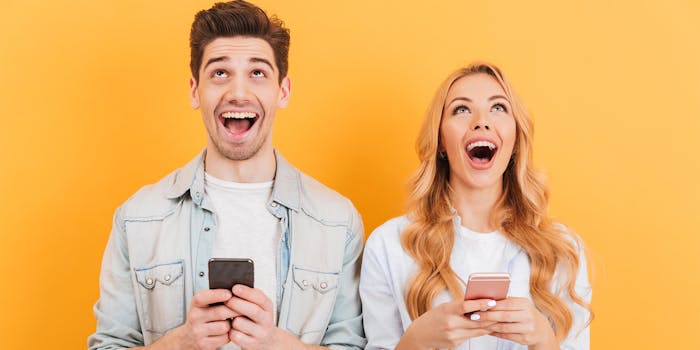 man and woman laughing at jokes on their phones