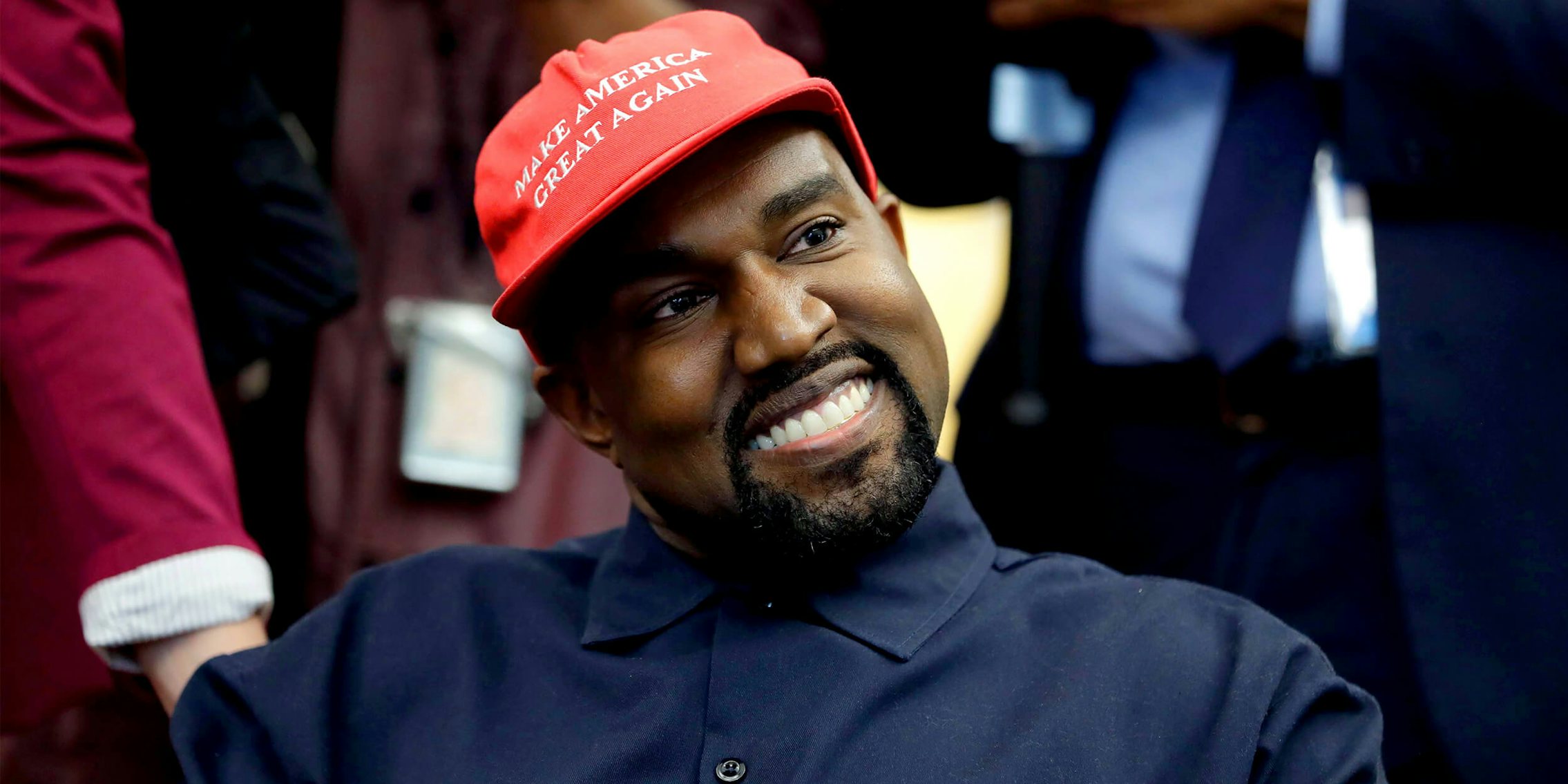 Kanye West smiling while wearing a Make America Great Again hat