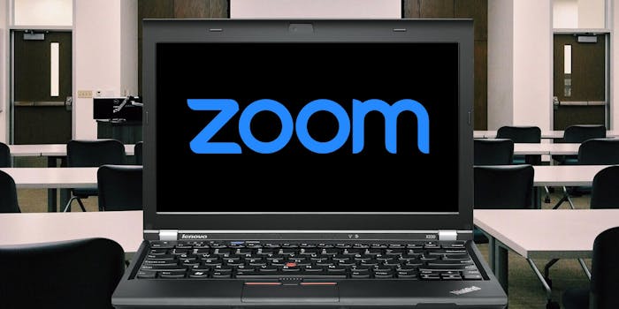 A laptop with the word zoom on its screen in a classroom
