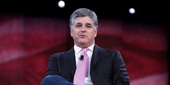 Fox News host Sean Hannity sitting on a stage