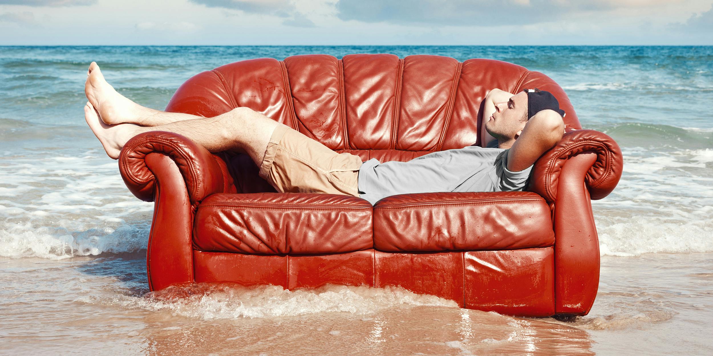 man laying on couch in the surf
