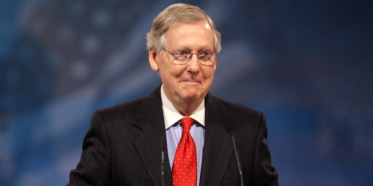 Mitch McConnell standing in front of American flag