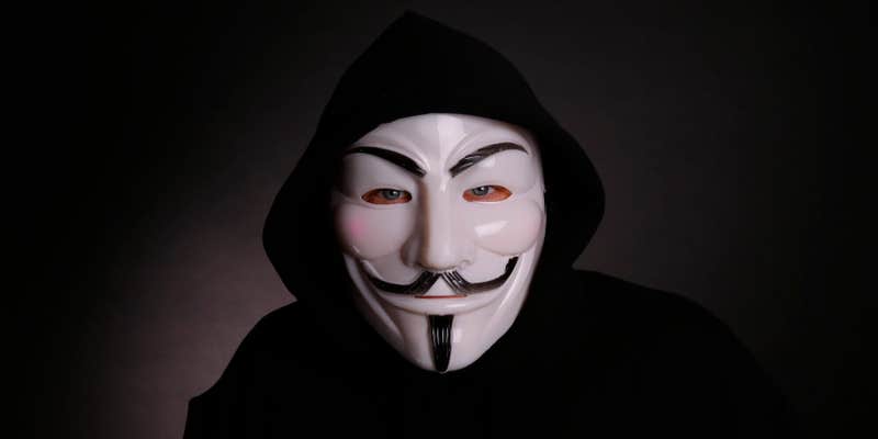 A man wearing a Guy Fawkes mask associated with Anonymous