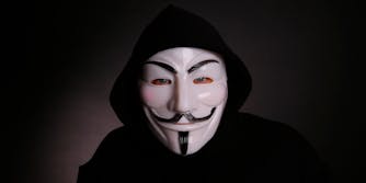 A man wearing a Guy Fawkes mask associated with Anonymous