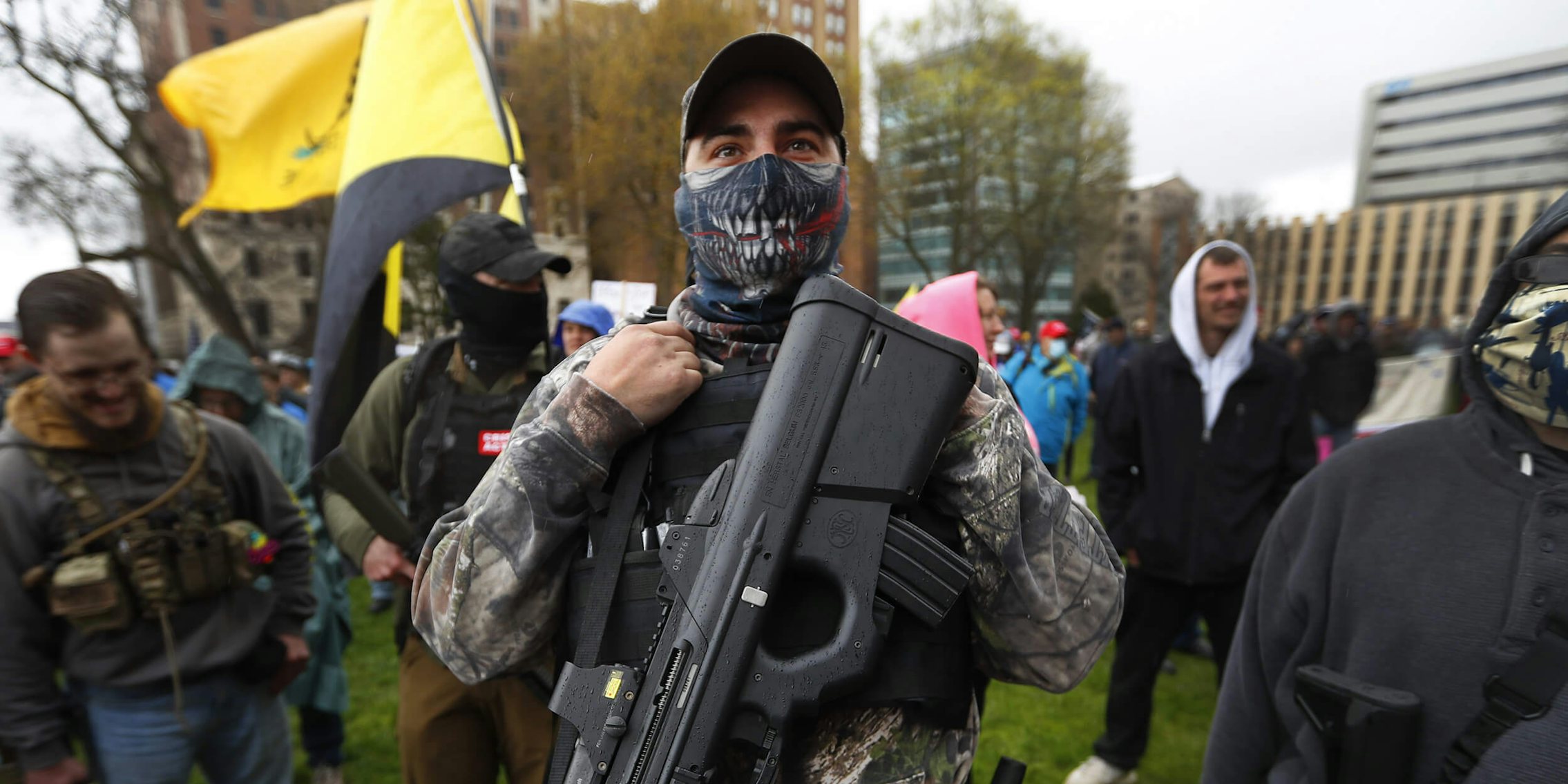 Protester carries his rifle at the State Capitol in Lansing, Mich.,