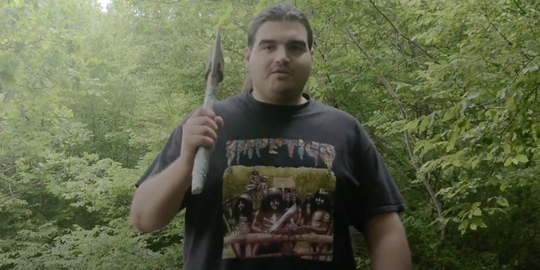 A Bosnian YouTuber holding an axe in the woods