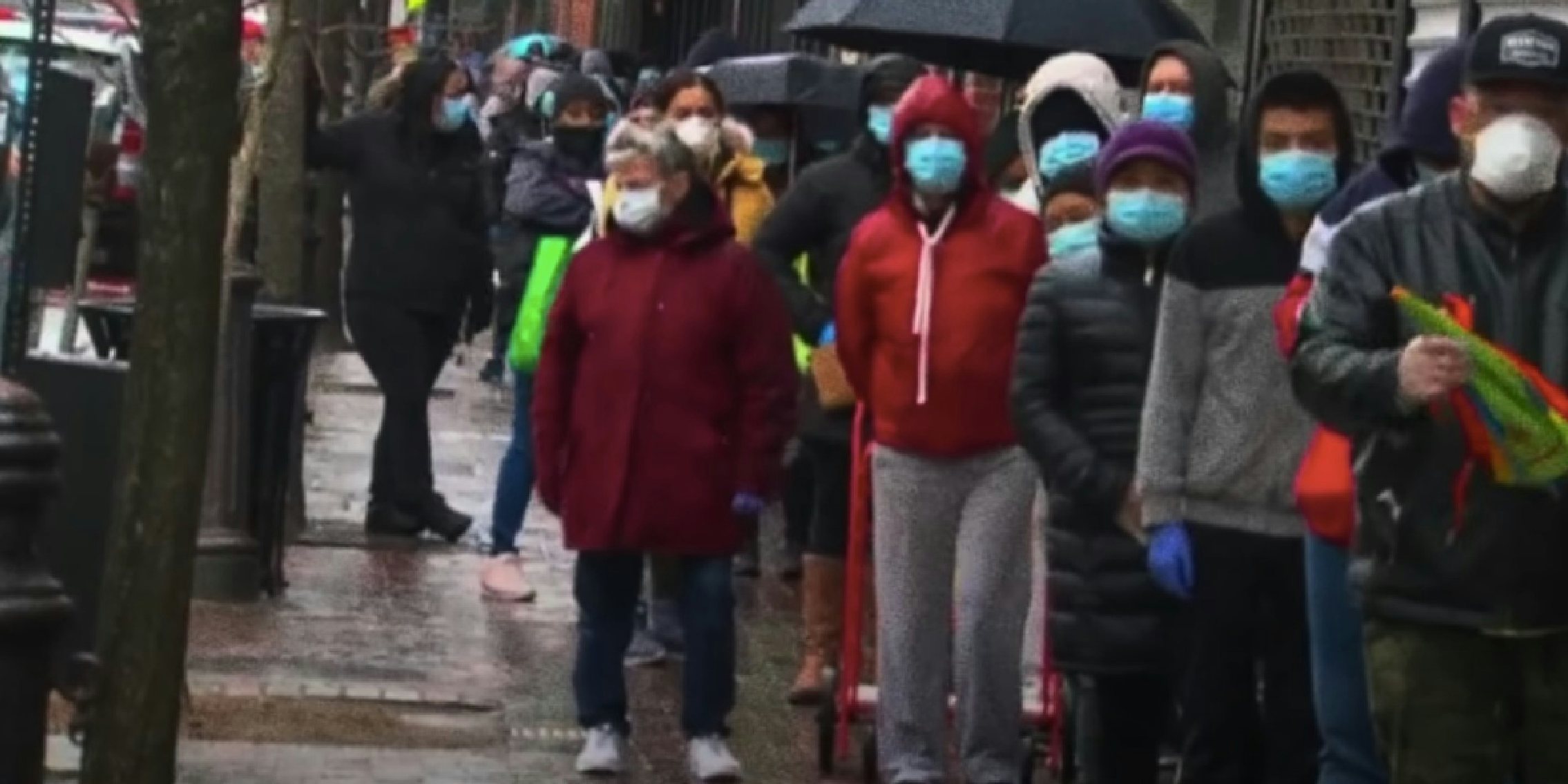 people waiting in line with face masks on