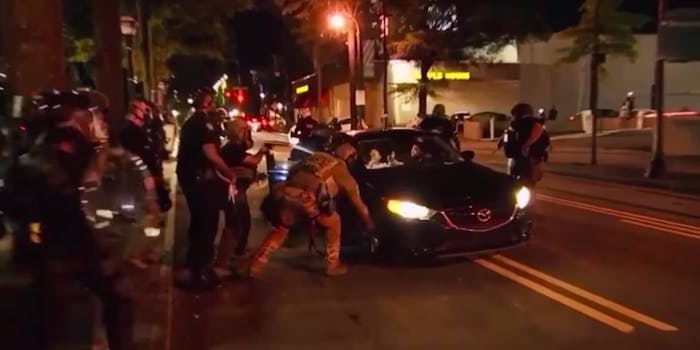 Screengrab shows about a dozen cops swarming the scene where cops attacked two college students